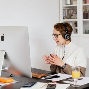 Mujer trabajando en computadora hablando por telefono